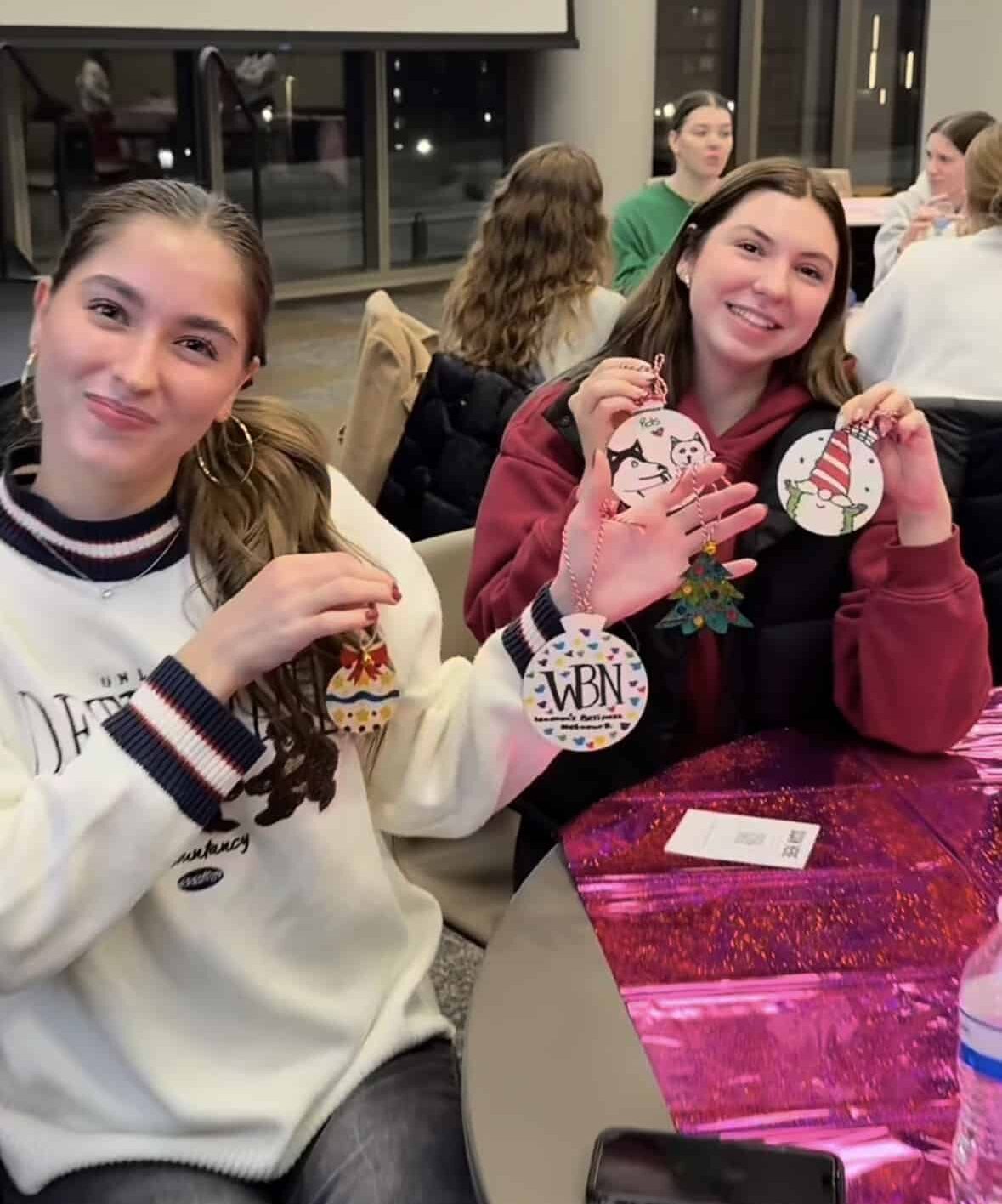 two women holding up ornaments
